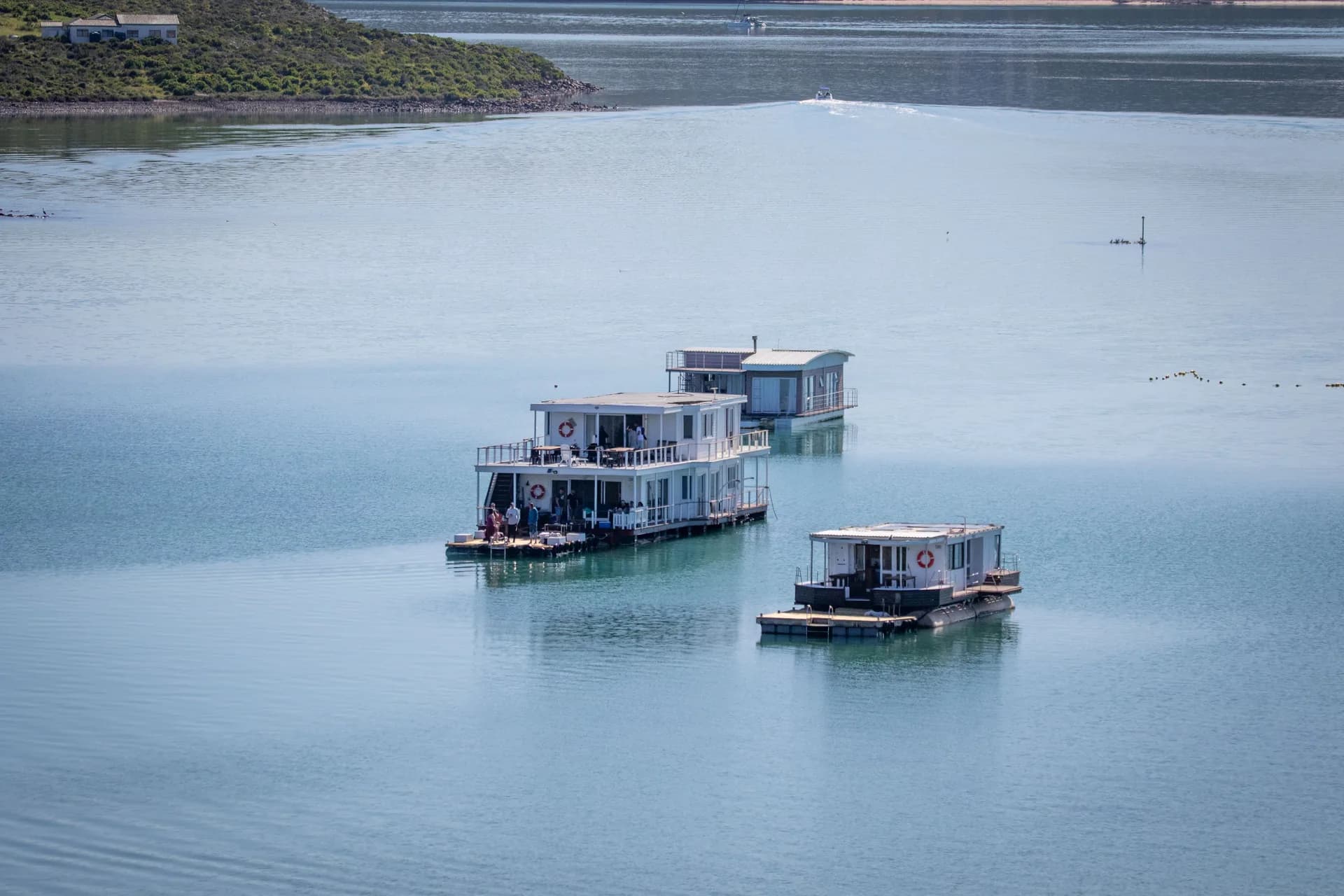 BookNoFees sample image: Three houseboats on the calm waters of a lagoon