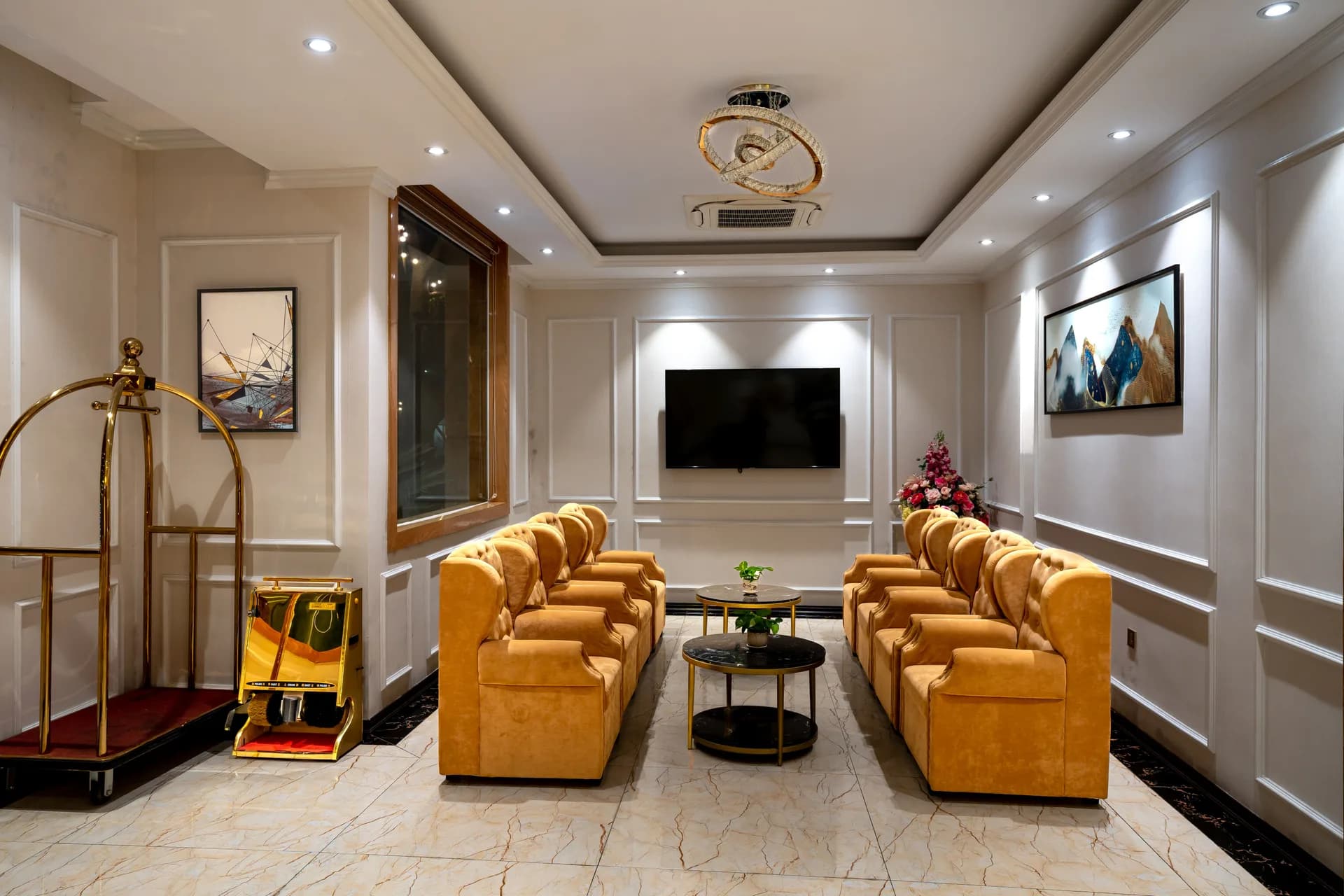 BookNoFees sample image: Bright hotel lobby with gold-colored armchairs and luggage carts