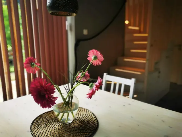 BookNoFees: transient house sa Hieflau, Styria, Austria – Kainan na may puting mesa, plorera ng kulay rosas na bulaklak, at kahoy na hagdanan