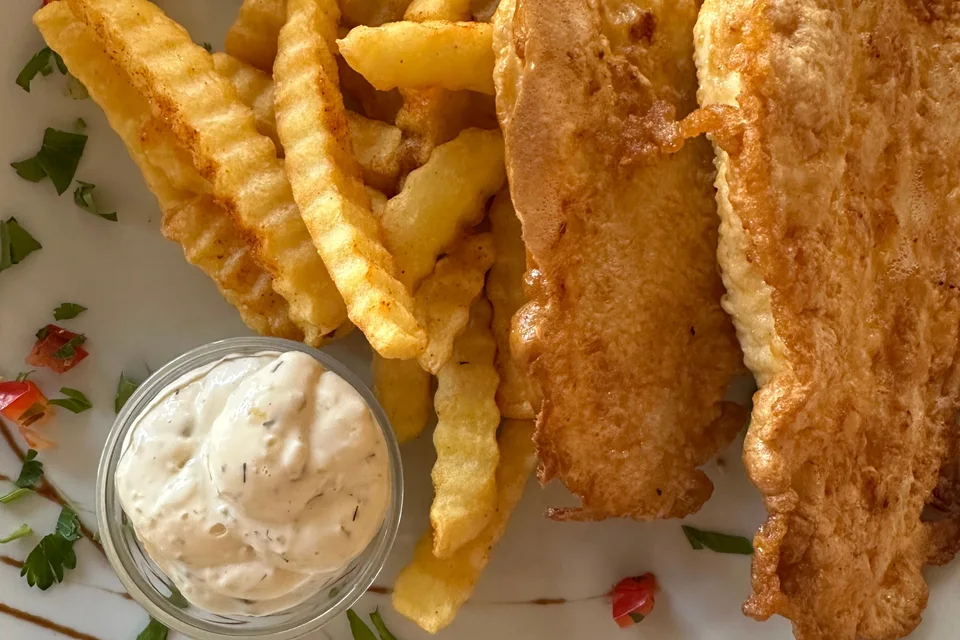 BookNoFees: Halimbawa ng larawan: Pinahiran ng batter na fillet ng isda na may crinkle-cut chips at isang maliit na mangkok ng sarsa