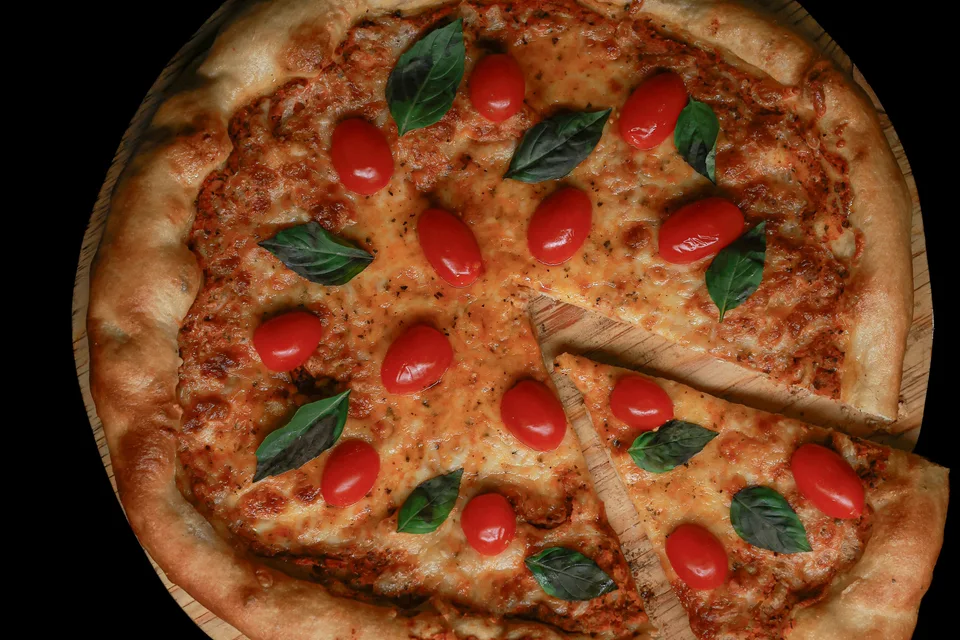 BookNoFees: Halimbawa ng larawan: Pizza na may topping na kamatis at basil
